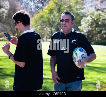 Zwei Rugby World Cup 2011 Unterstützer New Zealand All Blacks Hemden tragen. Ein Betrieb einen Souvenir World Cup Rugby-Ball. NZ Stockfoto