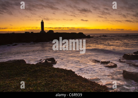 Point Arena Lighthouse in Kalifornien, bei Sonnenuntergang, mit Sturm kommt in den Pazifik mit krachenden Wellen. Keepers House kann gemietet werden. Stockfoto