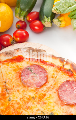 Italienisches original dünne Kruste Peperoni-Pizza mit frischem Gemüse auf Hintergrund Stockfoto