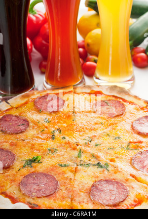 Italienisches original dünne Kruste Peperoni-Pizza mit Auswahl an Bieren und Gemüse auf Hintergrund Stockfoto