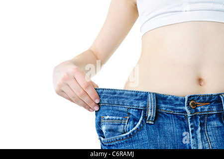 Fit junge Frau in loose Jeans nach Abnehmen isoliert auf weiss Stockfoto