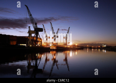 Krane auf der BAE-Werft auf dem River Clyde, Glasgow, Schottland Silhouette gegen den Himmel. Stockfoto