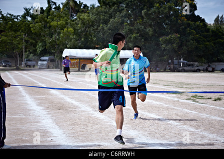 Sieger über die Ziellinie bei einem asiatischen Schule Sport Tag Event. S. E. Asien Thailand Stockfoto