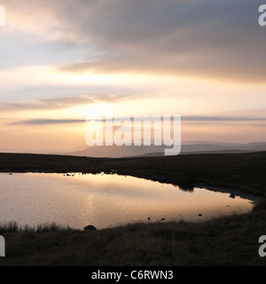 Sonnenaufgang über dem Peny Fan und die zentralen Leuchtfeuer von den Ufern des Llyn y Fan Fawr im Black Mountain Bereich der Brecon Beacons Stockfoto