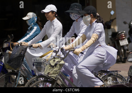 Sekundäre Schulmädchen in Vietnam tragen elegante weiße Chong Sams und versuchen, ihre Gesichter, Arme und Hände gleichermaßen als weiß. Stockfoto