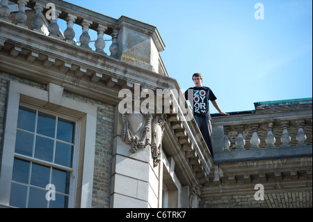 Eine junge männliche, urban Runner, entlang Brüstung auf Dach des hohen Gebäude im Zentrum von Cambridge. Stockfoto