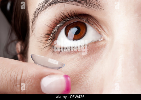 Frau eine Kontaktlinse auf dem Auge anwenden Stockfoto