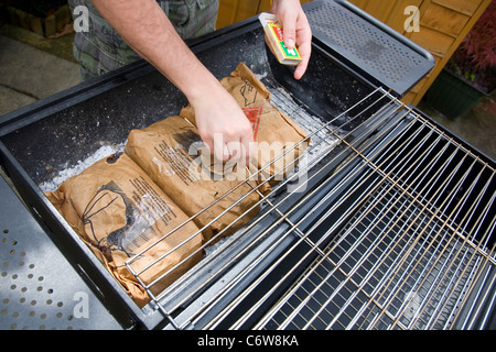 Mann mit Instant Beleuchtung Lumpwood Holzkohle BBQ Stockfoto