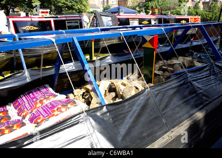 Eine Ladung Kohle und Holz verladen eines traditionellen arbeiten Narrowboat, beladen mit Kohle, smokeless Kraftstoff, Protokolle, vor Anker Stockfoto