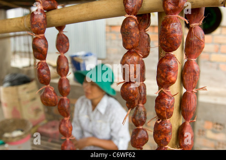 Frau verkaufende Würstchen, an einem Straßenrand Markt in Phnom Sprung Village, in der Nähe von Siem Reap, Kambodscha Stockfoto