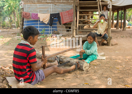 Kinder schneiden Protokolle mit einer zweihändigen sah, Phnom Sprung Dorf in der Nähe von Siem Reap, Kambodscha Stockfoto