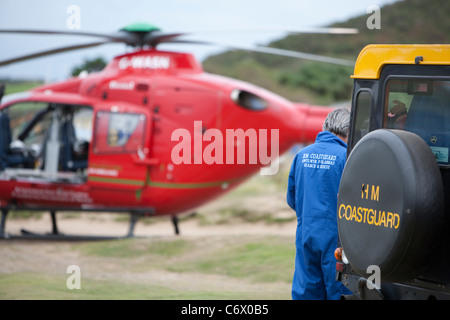 Coast Guard rescue Team unterstützen mit Wales Air Ambulance Notfallrettung Stockfoto