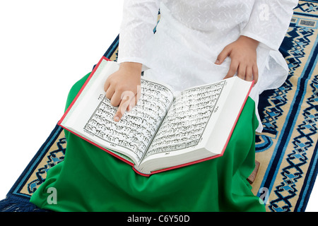 Muslimische Junge liest den Koran Stockfoto