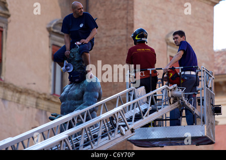 IT: Bologna, kletterte ein marokkanischer Flüchtling auf der Nettuno Statue in Piazza Maggiore, protestieren für die Aufenthaltserlaubnis. Stockfoto