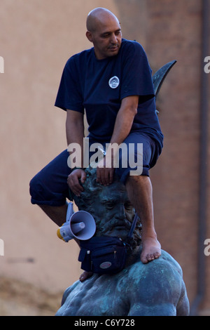 IT: Bologna, kletterte ein marokkanischer Flüchtling auf der Nettuno Statue in Piazza Maggiore, protestieren für die Aufenthaltserlaubnis. Stockfoto