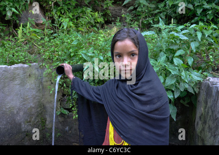 Ein Sunuwar Mädchen von Danda Phaya, sammelt Sunuwar Dorf am Simikot Humla Trinkwasser aus dem Wasserhahn Gemeinschaft. Stockfoto