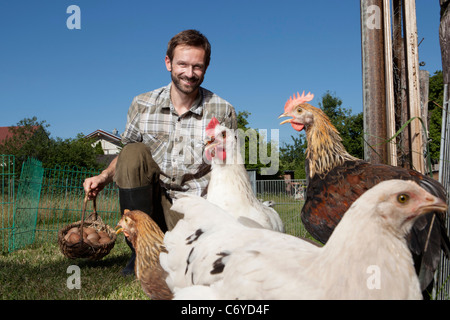 Mann im freien Hühner füttern Stockfoto