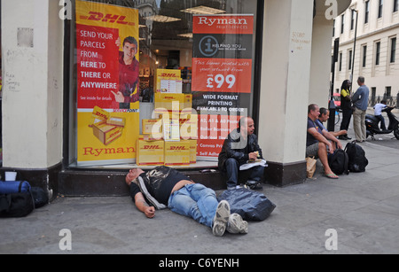 Männlich, die möglicherweise durch die Auswirkungen von Alkohol in einem Hauseingang entlang The Strand in London Großbritannien im Laufe des Nachmittags schlafen Stockfoto