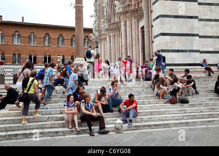 Blick auf die Stadt Siena, Toskana, Italien, mit gotischen Dom (Duomo) und müde Touristen Ruhe und Entspannung auf Treppe Stockfoto