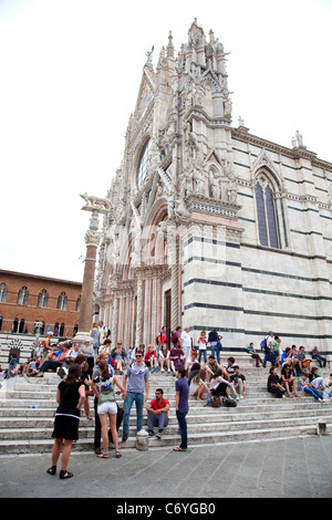 Blick auf die Stadt Siena, Toskana, Italien, mit gotischen Dom (Duomo) und müde Touristen Ruhe und Entspannung auf Treppe Stockfoto