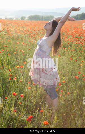 Schwangere Frau in Blumenfeld Stockfoto