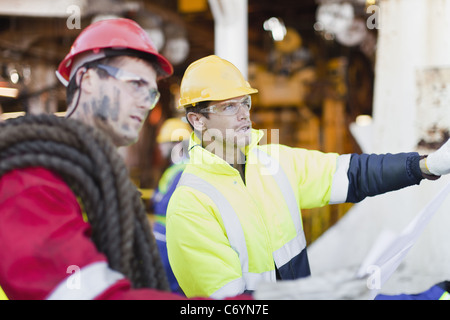 Arbeitnehmer, die Prüfung der Baupläne auf Bohrinsel Stockfoto