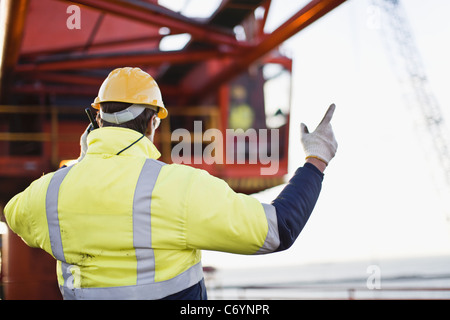 Arbeiter mit Walkie-Talkie auf Bohrinsel Stockfoto