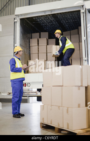 Arbeitnehmer-Boxen von LKW entladen Stockfoto