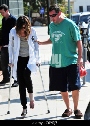 Adam Sandler hilft seiner Frau Jackie, als sie auf ihre Krücken geht, nach dem Mittagessen. Los Angeles, Kalifornien, USA - 13.03.10 Stockfoto