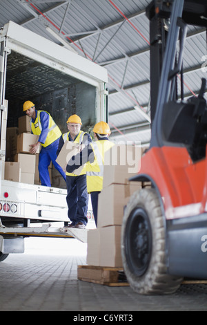 Arbeitnehmer-Boxen von LKW entladen Stockfoto