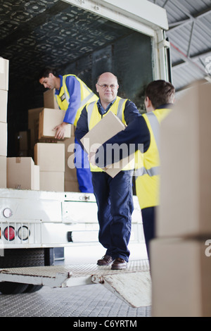 Arbeitnehmer-Boxen von LKW entladen Stockfoto