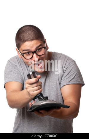 Eine lebenslustige Video Gamer spielen mit einem kabellosen Joystick vor einem weißen Hintergrund. Stockfoto