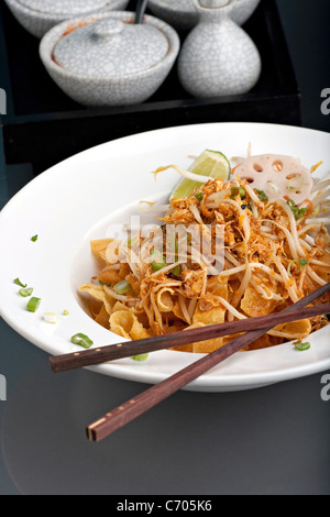 Ein thailändisches Gericht Crisy Nudeln und Sojasprossen in einer großen weißen Schüssel mit Stäbchen. Stockfoto