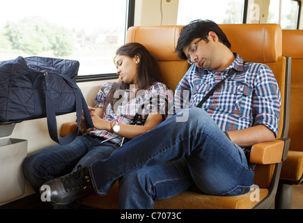 2 paar Leute paar eingeschlafen Snooze Zug Reisenden Touristen Pendler junge Mädchen Mann Frau müde erschöpft müde Reisende Stockfoto