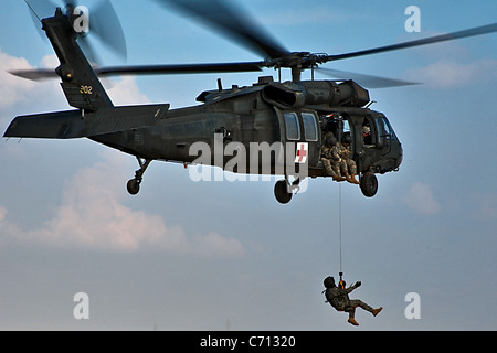 Ein Soldat baumelt aus einem UH-60 Black Hawk Hubschrauber, wie er während einer Hebezeug-Übung unter der Leitung von Unternehmen C, 2. Bataillon, 227. Aviation Regiment, 1st Air-Kavallerie-Brigade, 1. Kavallerie-Division, US-Division-Center 21 Jan. bis zum Boden abgesenkt wird. Das Training wurde von mehreren unterschiedlichen Höhenlagen durchgeführt, so dass die Medevac-Mannschaften sich am Hebezeug Operationen vertraut machen konnte. Stockfoto