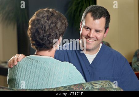 Eine Krankenschwester tröstet einen Besucher im Wartezimmer eines Krankenhauses. Stockfoto