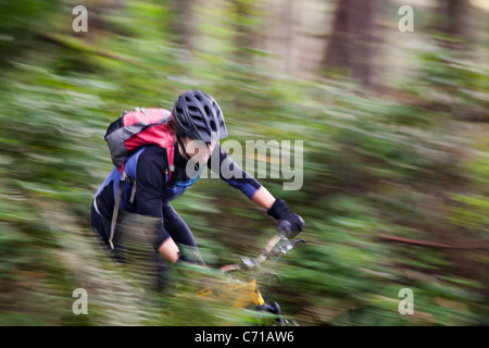 Eine Frau windet sich durch eine Mountainbike-Strecke eingleisig. Stockfoto