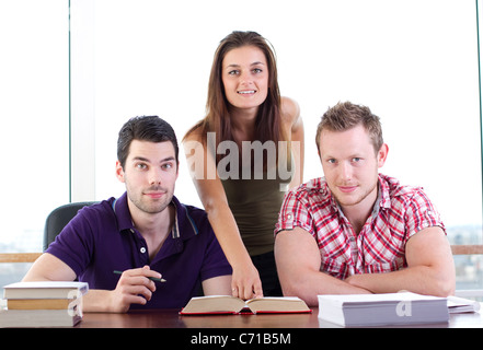 Attraktive junge Frau lehrt zwei junge Studenten Stockfoto