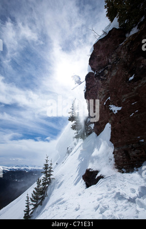 Ein männlicher Skifahrer springt von einer Klippe an einem sonnigen Tag in Colorado. Stockfoto