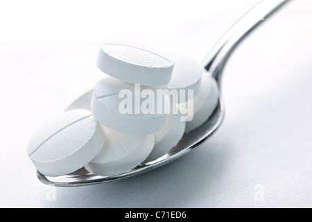 Calcium Supplement Pillen gestapelt auf Metalllöffel closeup Stockfoto