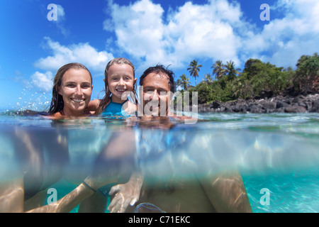 Ein Split-Level-Blick auf eine junge Familie im Wasser in Waimea Bay. Stockfoto