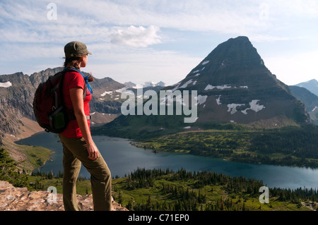 Eine junge weibliche Wanderer blickt auf verborgenen See und Bear Hut Mountain im Glacier National Park, Montana. Stockfoto