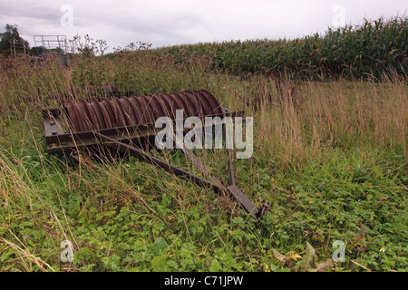 Alten verwilderten Landmaschinen Lügen verfallenen in einem Feld Stockfoto