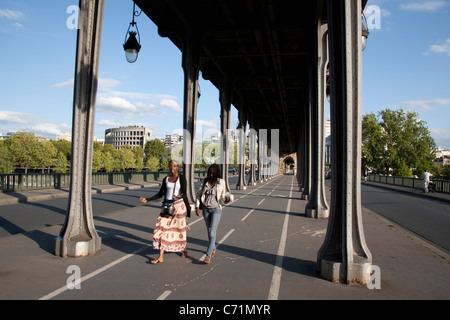 Zwei junge Frauen gehen unter der Brücke Pont de Bir Hakeim in Paris, Frankreich Stockfoto