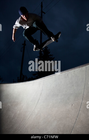 Ein glücklicher sportlicher Mann skateboards in der Nacht in Idaho. Stockfoto