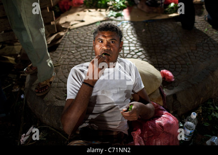 Ein Mann kaut und vertreibt Khat (Qat) in der Nacht Khat Markt in Aden, Jemen. Stockfoto