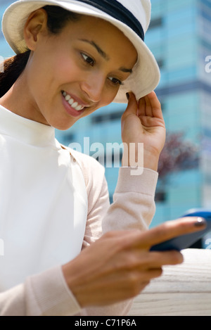 Frau mit Hut Text messaging, niedrigen Winkel Ansicht Stockfoto