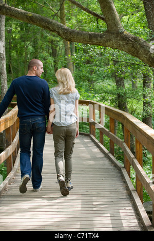 Paare, die am Boardwalk in Wäldern Stockfoto