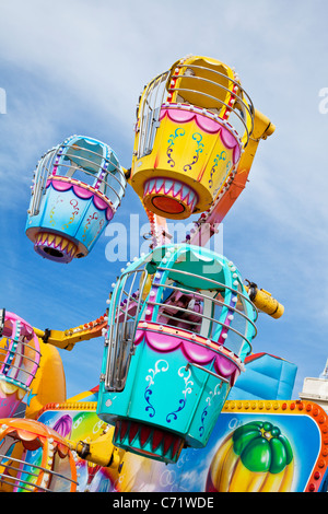 Pods auf einem Messegelände fahren vor einem blauen Himmel in leuchtenden Farben Stockfoto