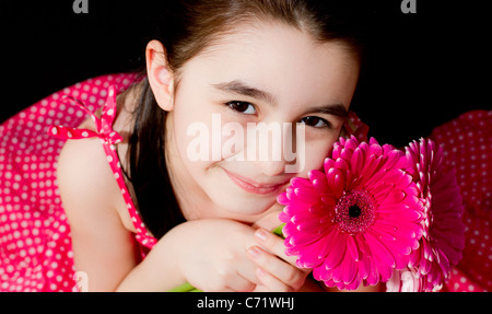 Niedliche kleine Mädchen mit rosa Blume. Stockfoto